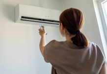 11 Air Conditioner Myths Busted! Woman turning on air conditioner with remote